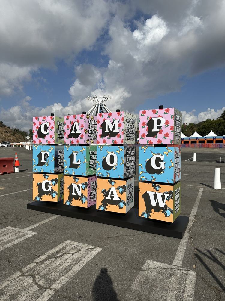 Cubos gigantes ilustrados con las letras de Camp Flog Gnaw en un festival