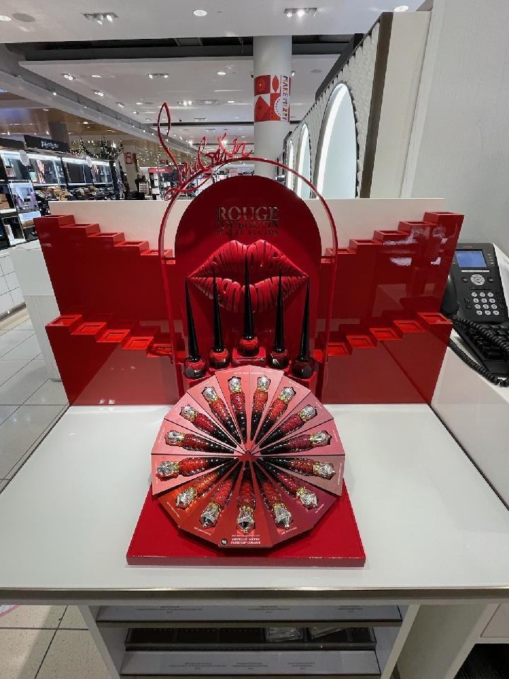 Exhibidor rojo de labiales Christian Louboutin con escultura de labios
