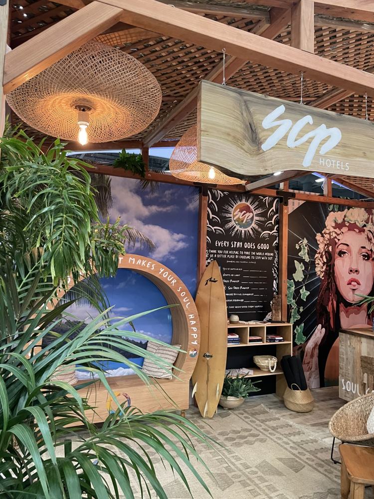 Pabellón de madera de SCP Hotels con plantas, tabla de surf y mural