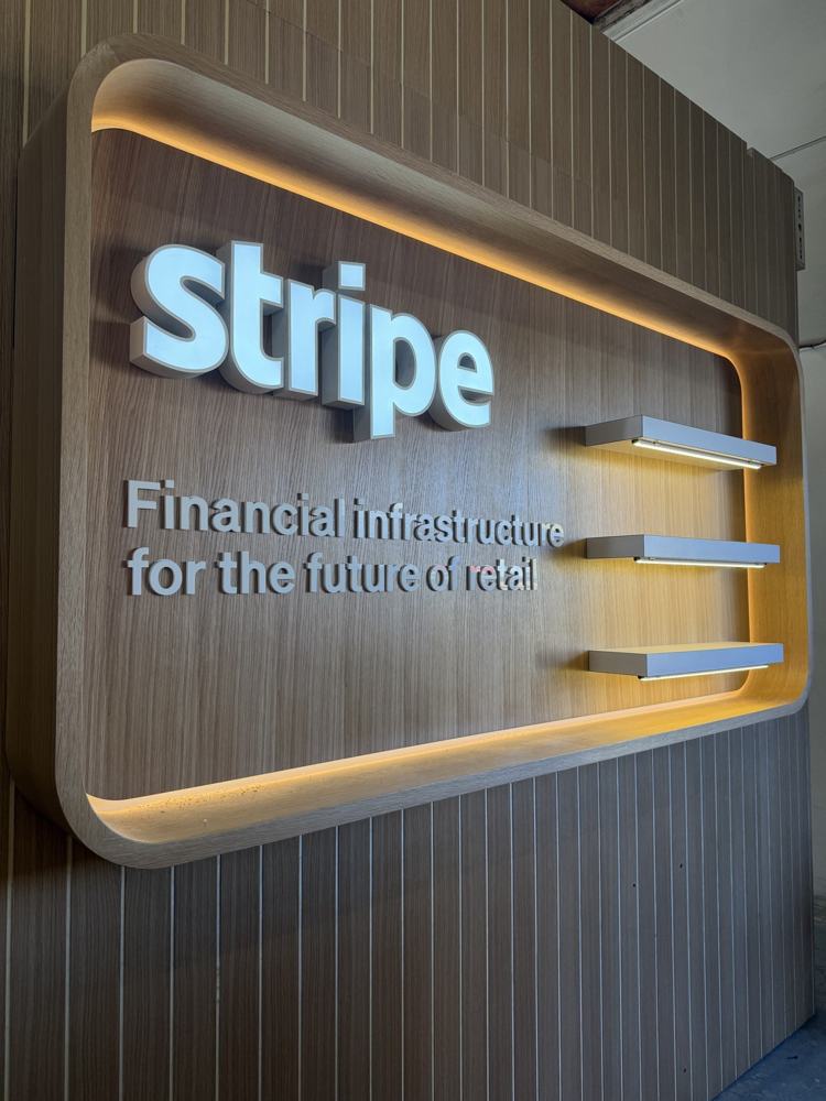 Muro retroiluminado con el logo de Stripe y repisas flotantes